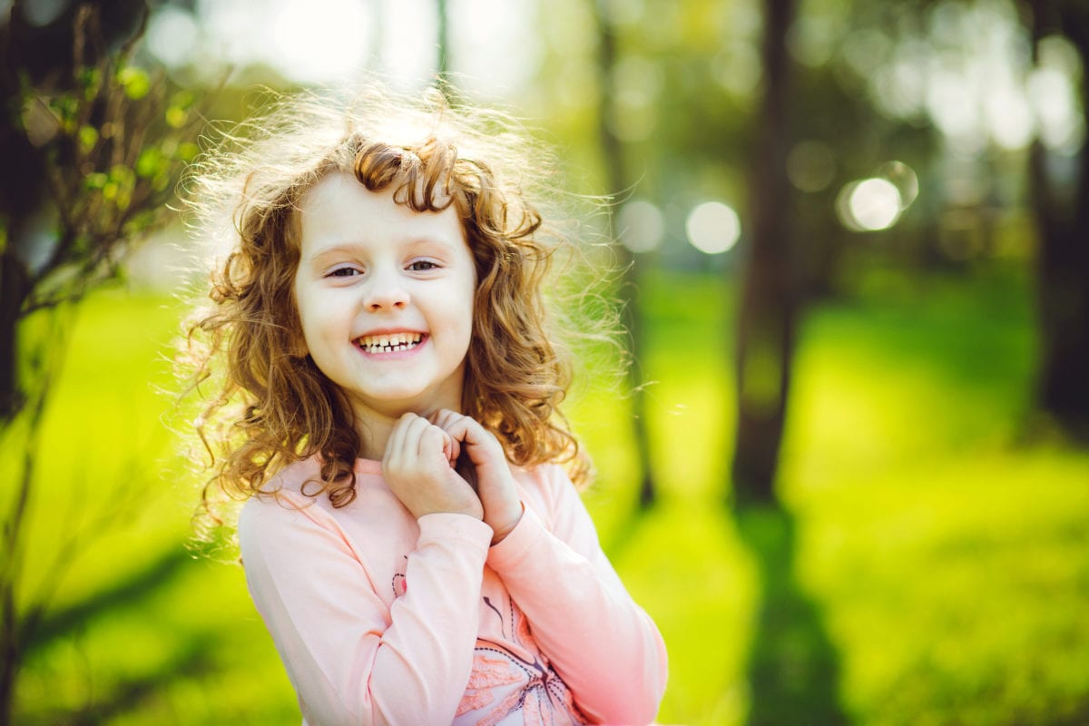 Smiling curly haired girl 30 Irish-Inspired Baby Names for Boys and Girls