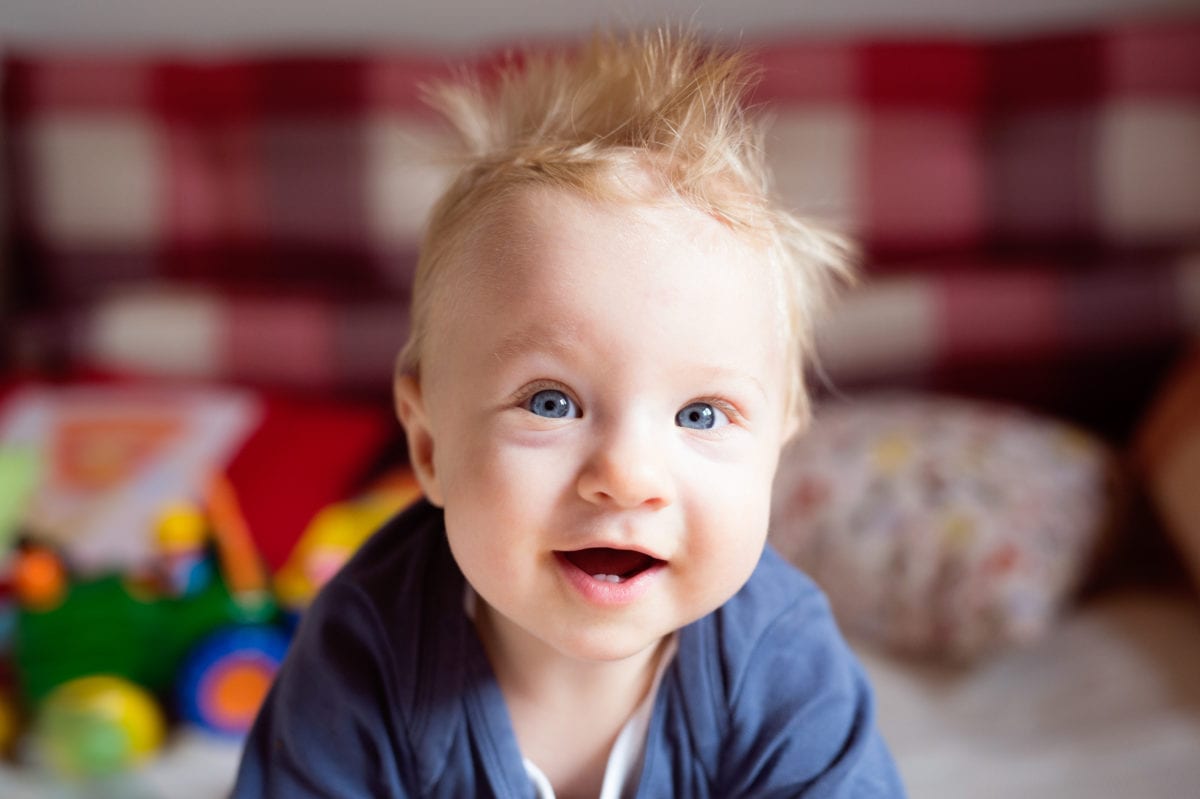 Little baby boy with spiky hair crawling on bed. 30 Irish-Inspired Baby Names for Boys and Girls