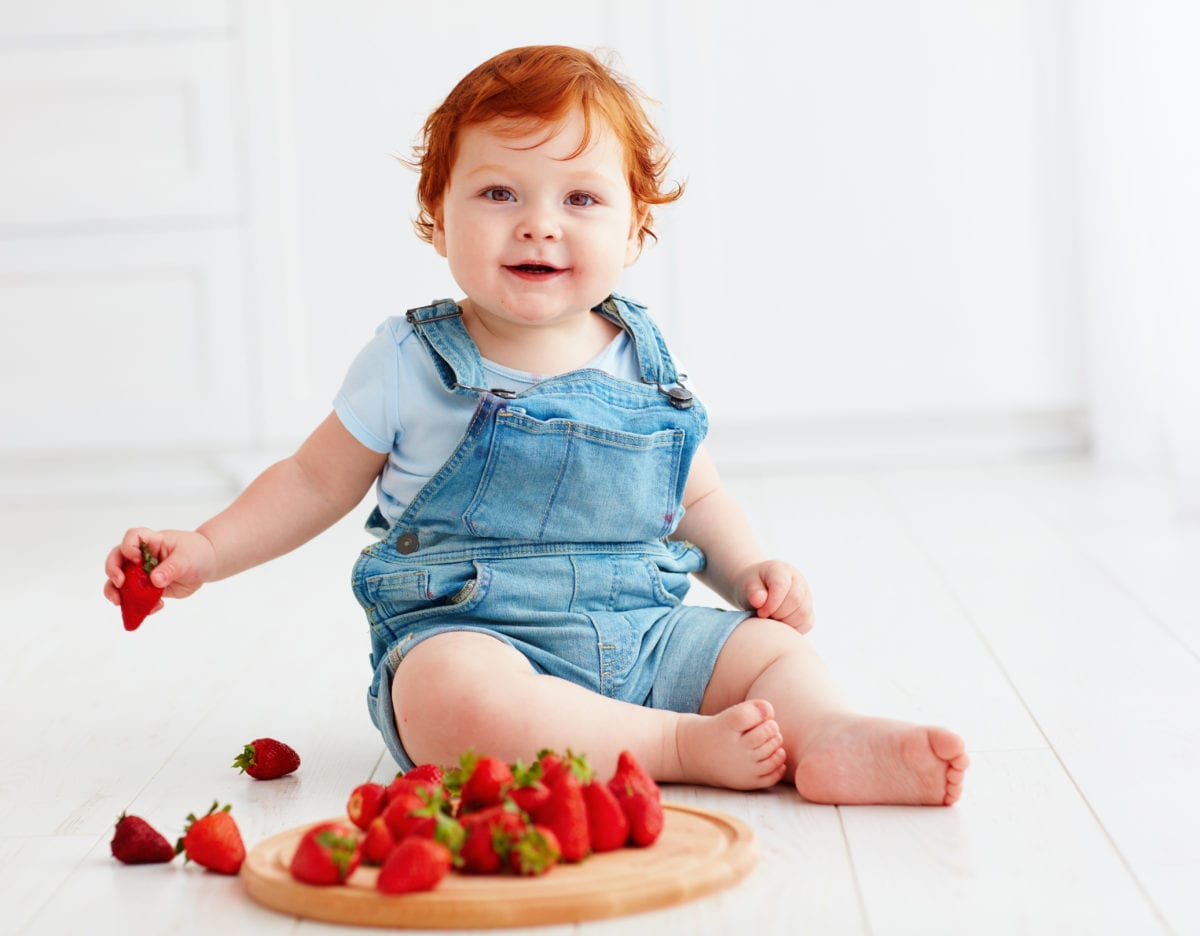 Red haired girl eating strawberries 30 Irish-Inspired Baby Names for Boys and Girls