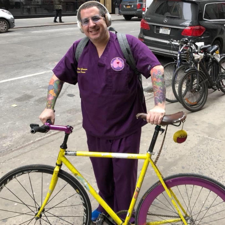 Dr. Noah Greenspan with his bike in NYC promoting his foundation's Free Covid-19 Rehabilitation Bootcamp